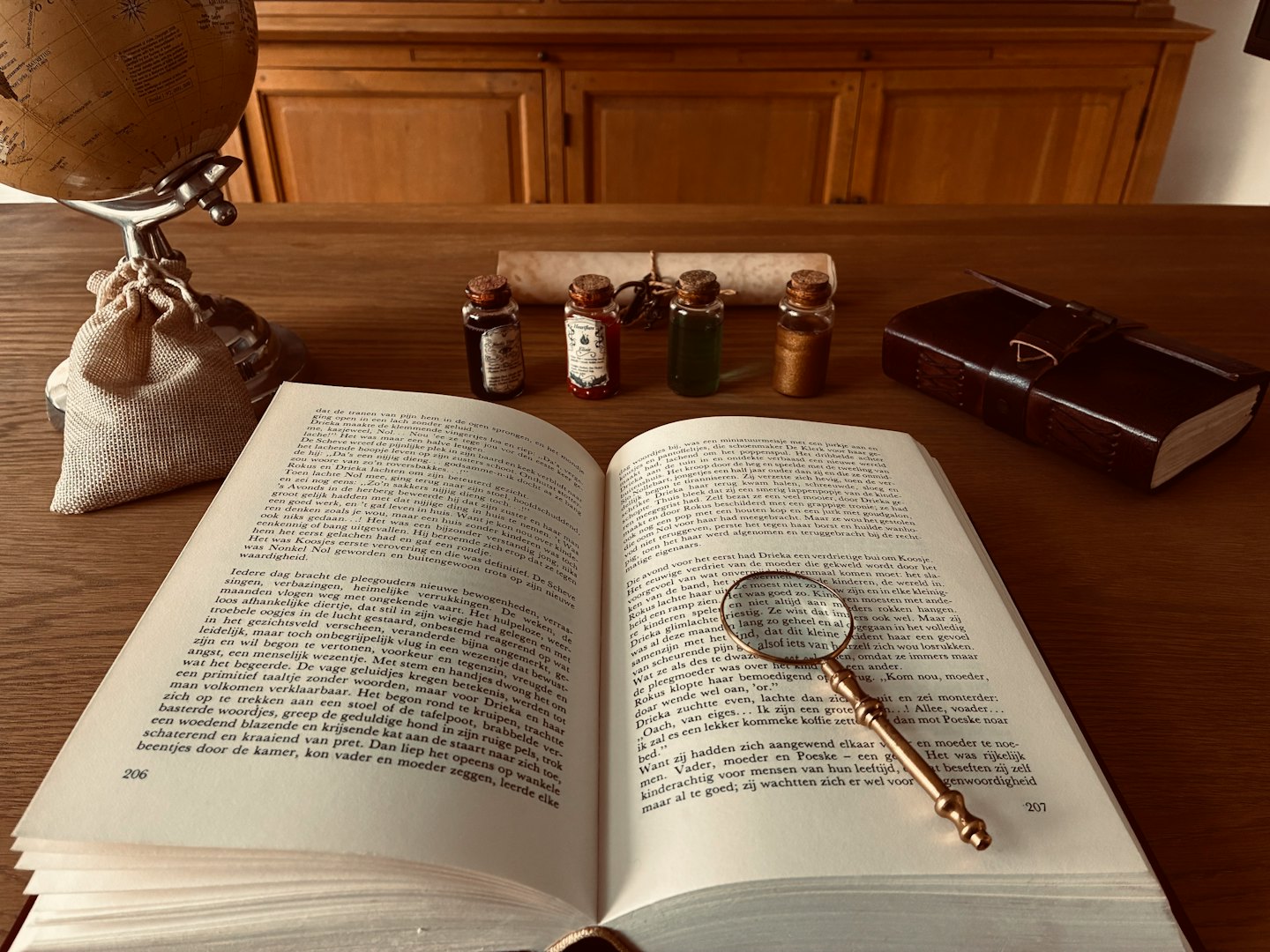 Una lente d'ingrandimento appoggiata su un libro aperto sulla scrivania.